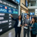 Five professionals stand together in a modern office, discussing a digital display titled Global Debt-to-GDP Ratios - 2024. Despite global concerns like the Canada Debt Crisis, Canada ranks first with a 43% ratio and Low Debt status among countries shown.