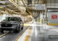 A gray Honda CR-V sits on a factory floor under bright lights. Signs mark it as the last U.S.-bound model made in Ontario due to tariffs, highlighting the broader industry shifts in lithium battery comparison, like LFP vs NMC battery choices.
