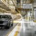 A gray Honda CR-V sits on a factory floor under bright lights. Signs mark it as the last U.S.-bound model made in Ontario due to tariffs, highlighting the broader industry shifts in lithium battery comparison, like LFP vs NMC battery choices.