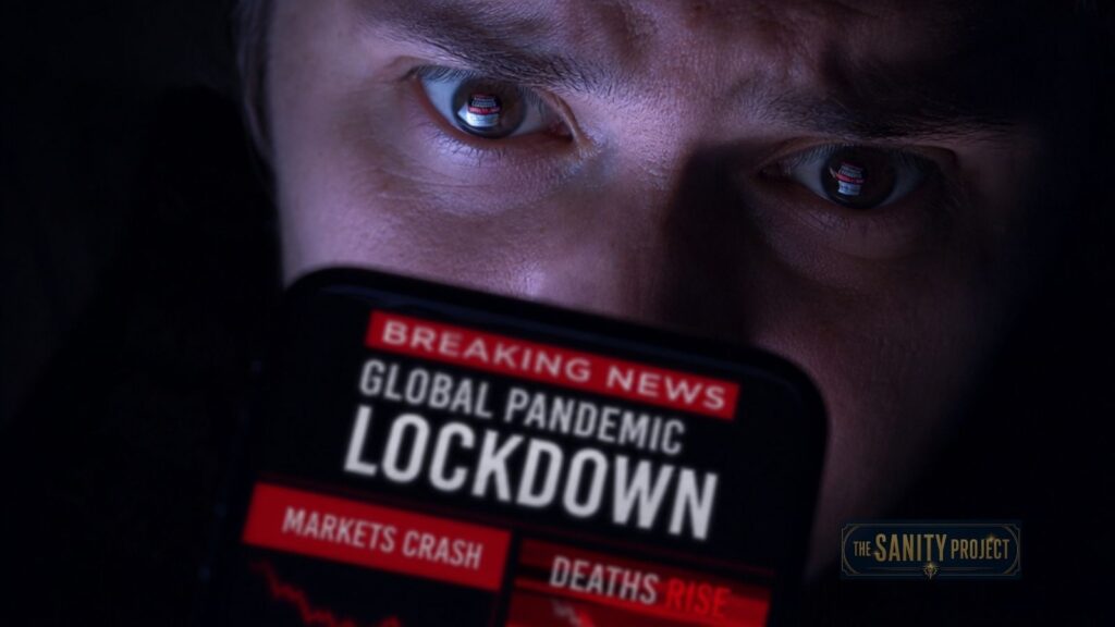 A person stares anxiously at a smartphone screen in the dark. The phone displays a news alert: "Breaking News: Global Pandemic Lockdown. Markets crash, deaths rise." It’s a striking example of what causes misleading headlines, reflected in their eyes.